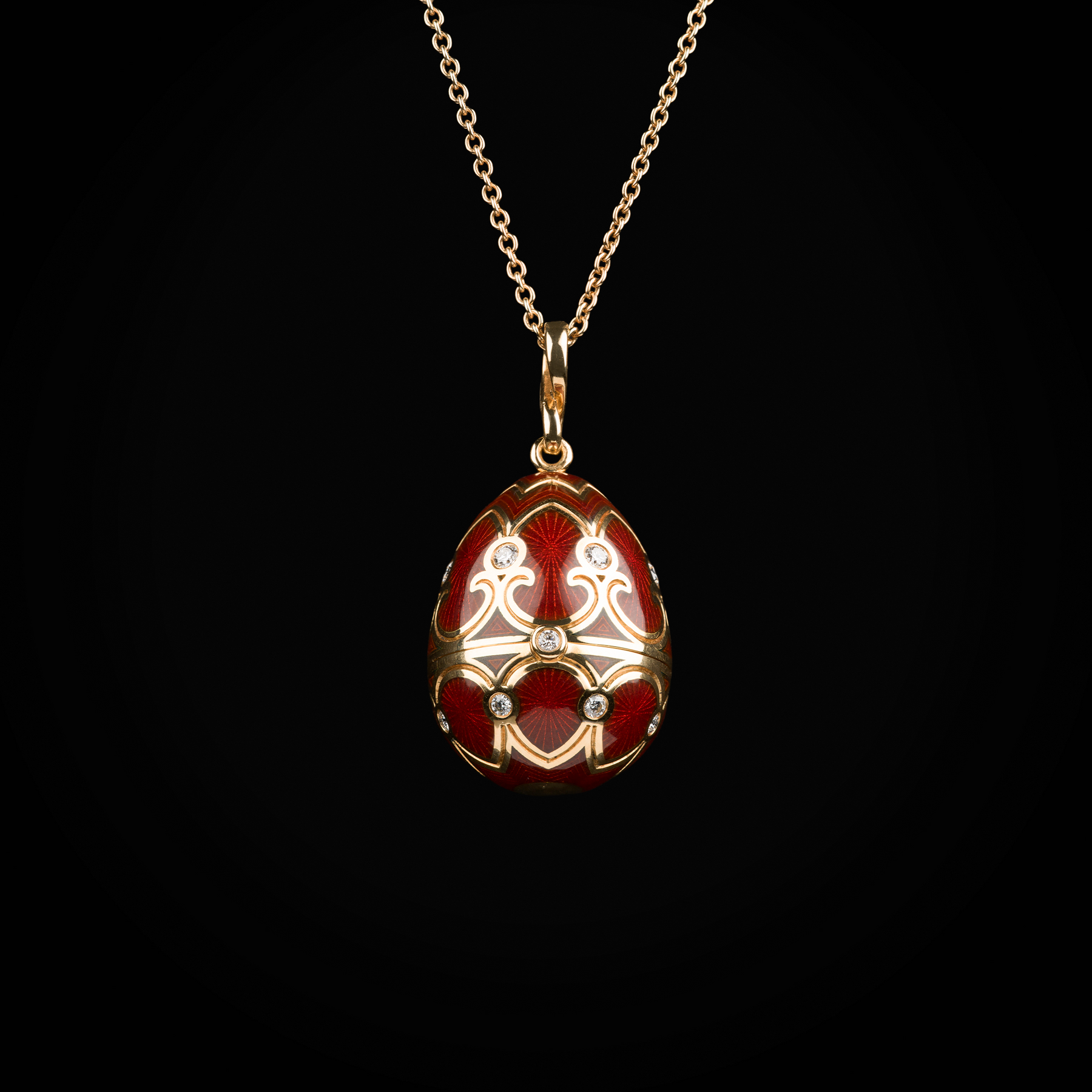 Cadena con dije huevo con esmalte guiloché vitreo rojo interior con carroza sobre plataforma de cornalina de oro amarillo 18k con diamantes naturales