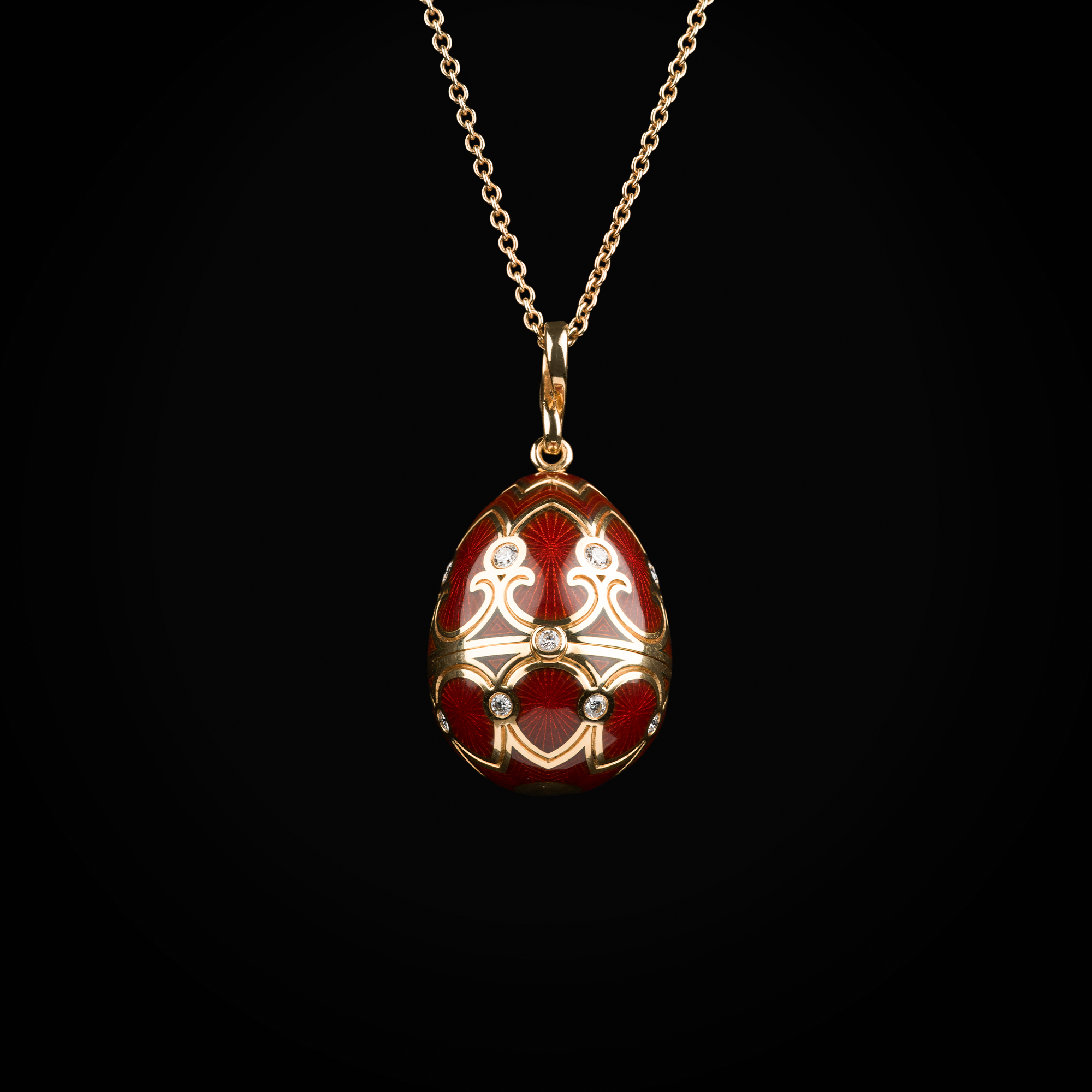 Cadena con dije huevo con esmalte guiloché vitreo rojo interior con carroza sobre plataforma de cornalina de oro amarillo 18k con diamantes naturales
