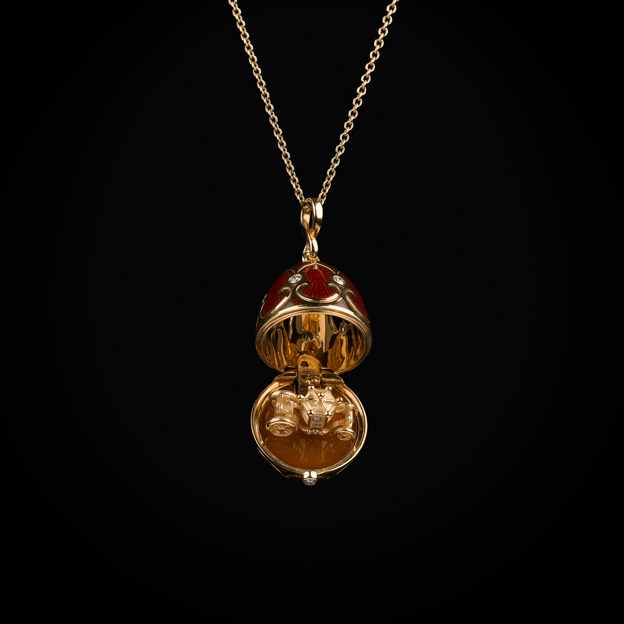 Cadena con dije huevo con esmalte guiloché vitreo rojo interior con carroza sobre plataforma de cornalina de oro amarillo 18k con diamantes naturales