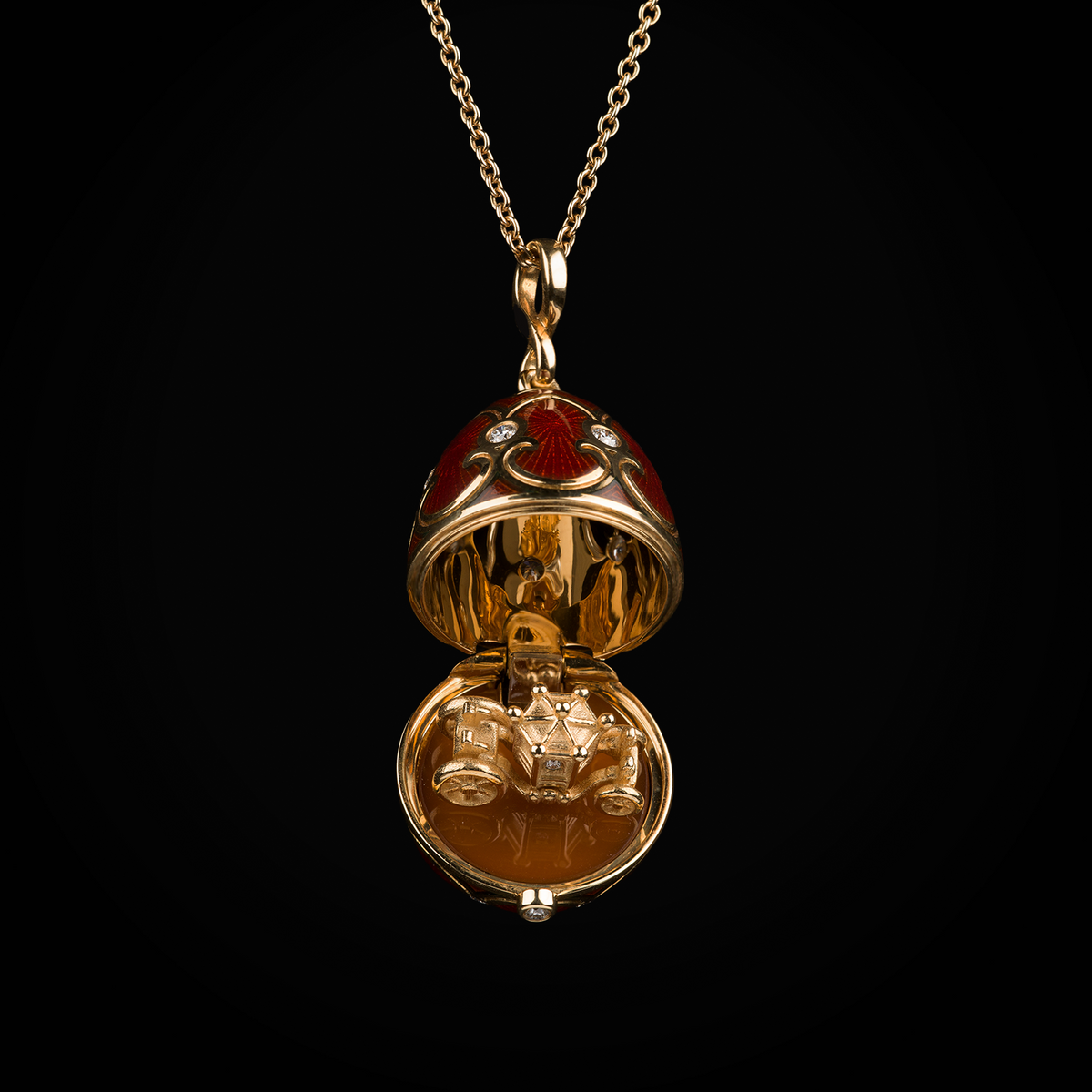 Cadena con dije huevo con esmalte guiloché vitreo rojo interior con carroza sobre plataforma de cornalina de oro amarillo 18k con diamantes naturales